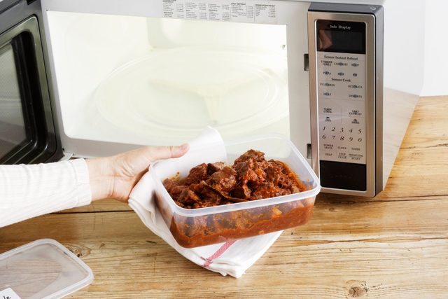 doctors eat for breakfast | woman heating leftovers in microwave