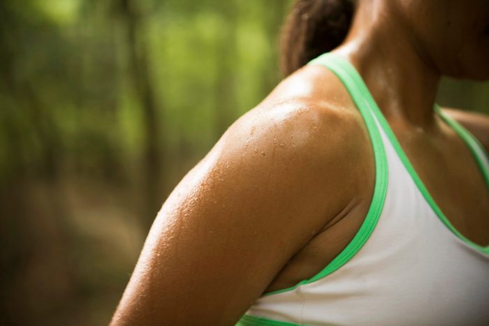 cause dehydration | close up of woman's sweaty shoulder outside during exercise