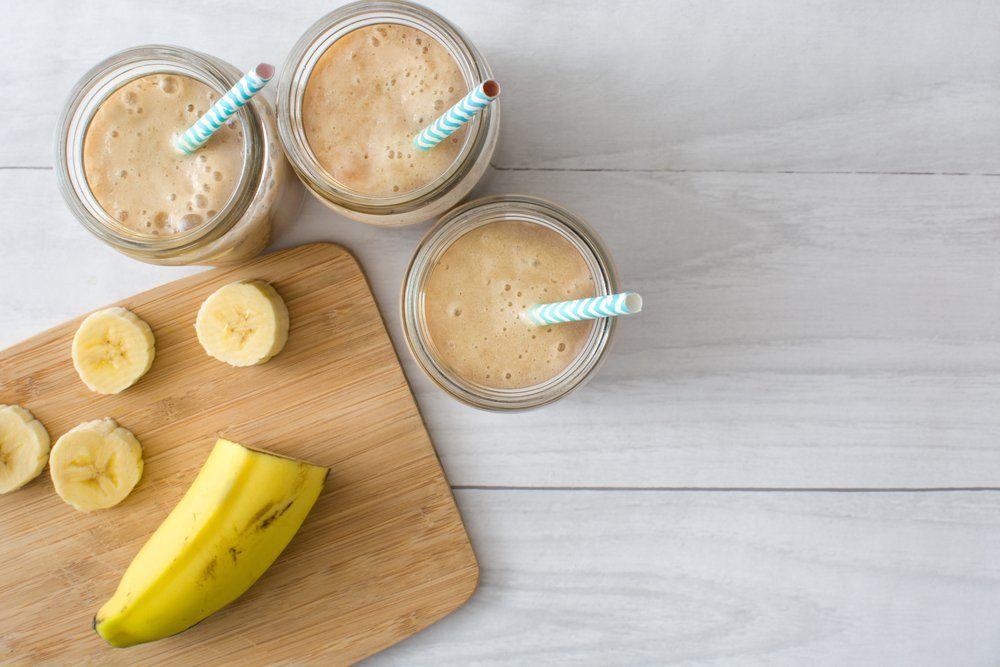plant-based snacks | Banana smoothie on a white wooden table