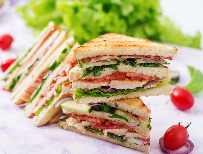 Club sandwich with chicken breast, bacon, tomato, cucumber and herbs | foods to avoid before workout
