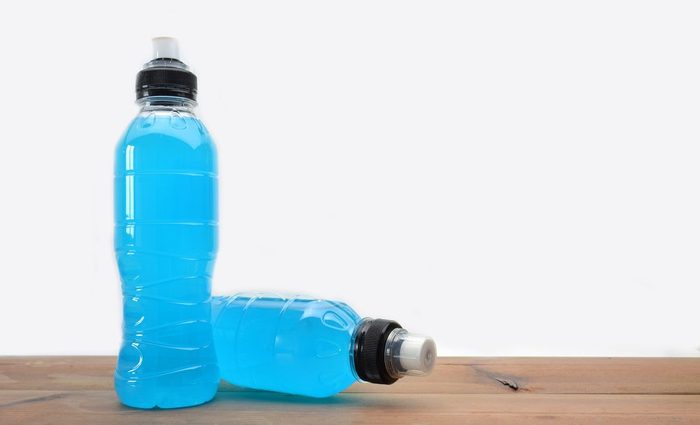 sports drink on wooden table and white background | foods to avoid before workout