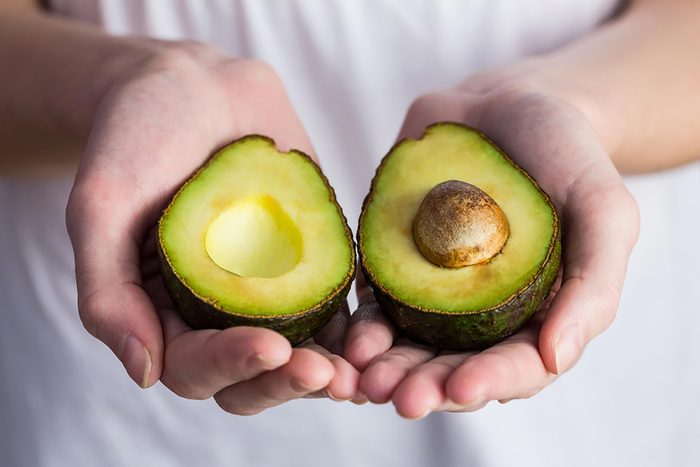 hands holding an avocado