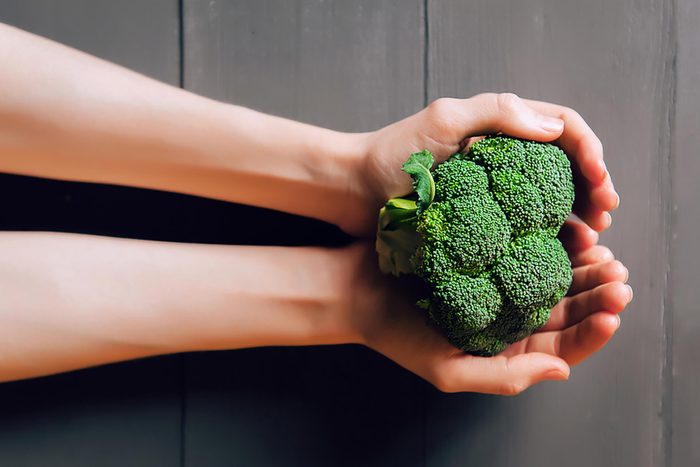 hands holding broccoli