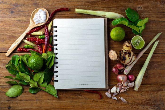 reach your goal weight | recipe book with fresh herbs south asia and spices on wooden background, thai food.