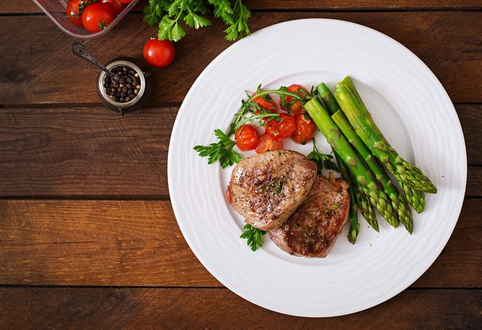 reach your goal weight | Barbecue grilled beef steak meat with asparagus and tomatoes. Top view