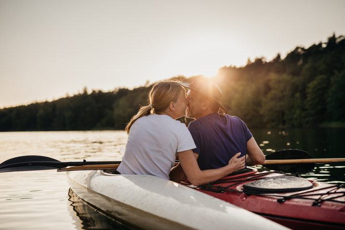 couple kissing while kayaking during sunset