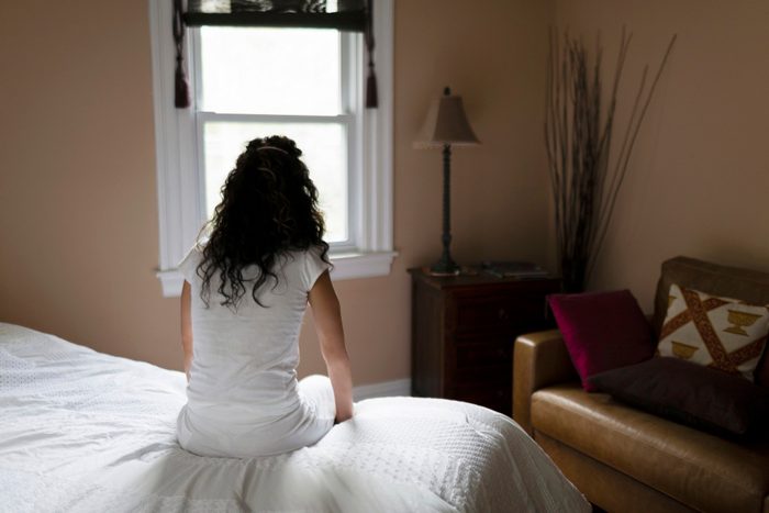 relationship fights | rear view of woman sitting on edge of bed