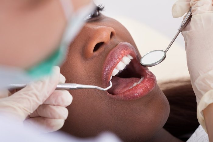 signs your body is in trouble | female patient having her teeth examined by dentist