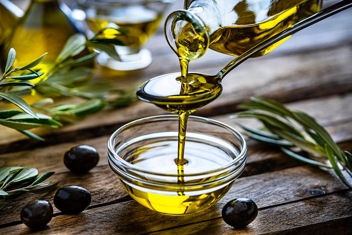 mediterranean diet | pouring extra virgin olive oil in a glass bowl