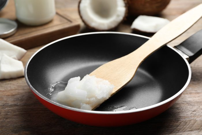 healthiest cooking oils | Frying pan with coconut oil and wooden spatula