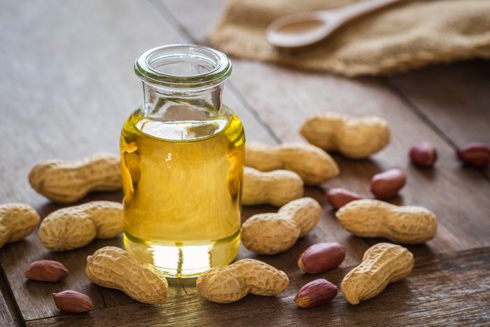 healthiest cooking oils | Peanut oil in glass bottle and peanuts 