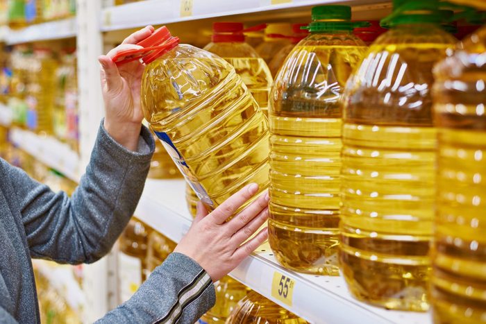 canola oil vs vegetable oil| Confused about the difference between canola and vegewoman taking large bottle of oil off of shelf at grocery store