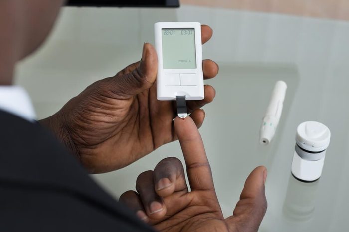 Close-up Of Patient Hands Measuring Glucose Level Blood Test With Glucometer