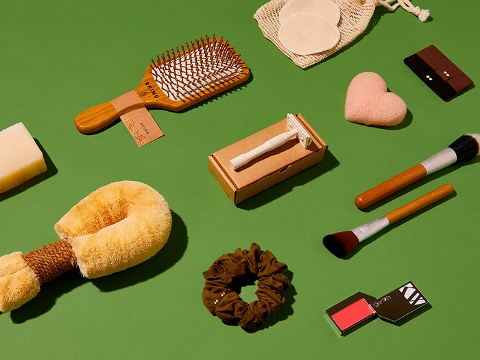 best sustainable beauty tools | flat lay of sustainable beauty tools on a green background