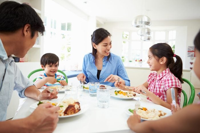 children healthy relationship with food | family talking and eating around a dinner table