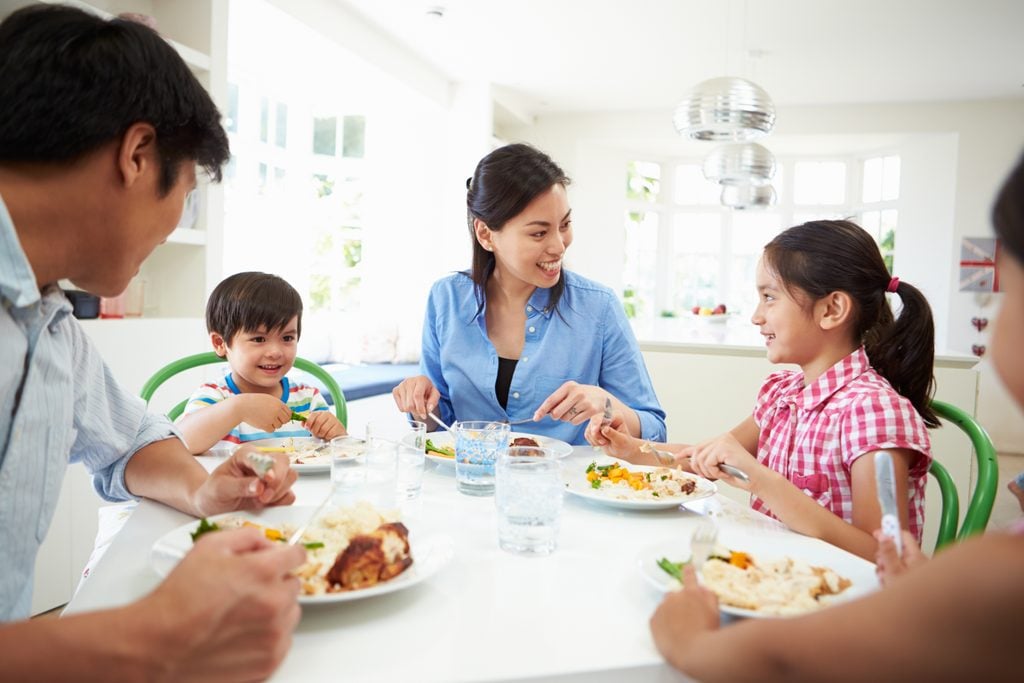 children healthy relationship with food | family talking and eating around a dinner table