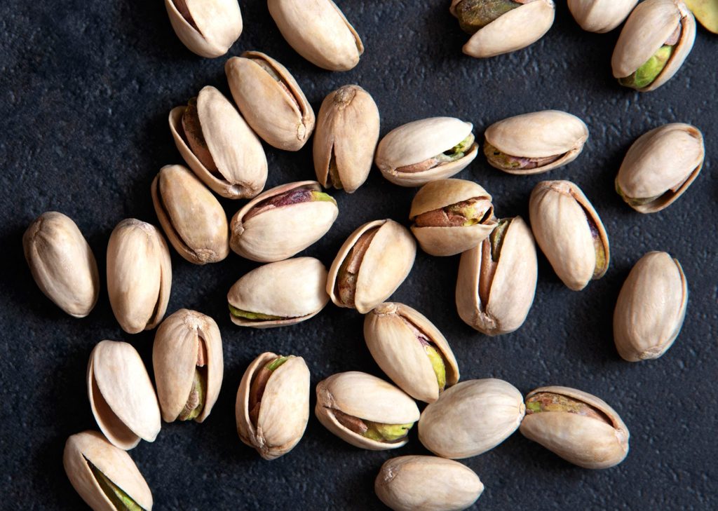 are pistachios good for you? | Roasted pistachios nuts on dark background. Healthy snack
