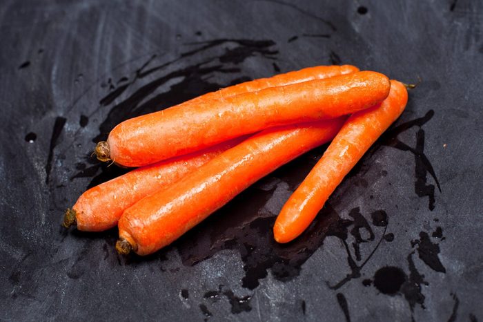 Fresh organic carrots on black background.