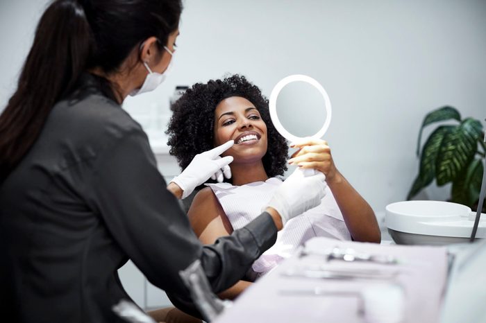 mamelon teeth | Patient Looking Teeth In Mirror At Dental Clinic