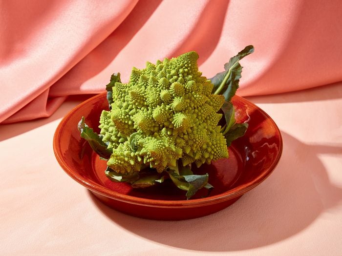 health benefits of romanesco | romanesco on plate in front of pink fabric