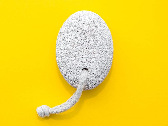 Natural,pumice,stone,with,white,rope,on,yellow,background.,pedicure