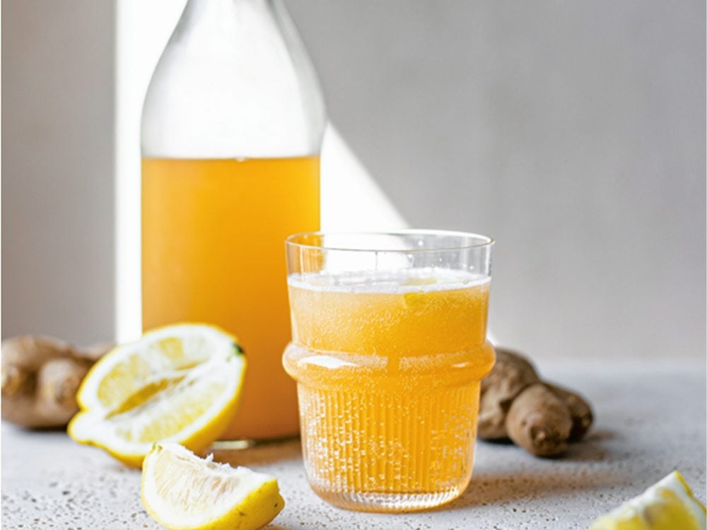 Ginger Beer Ginger Bug | image of ginger beer on a table next to fresh ginger and lemon