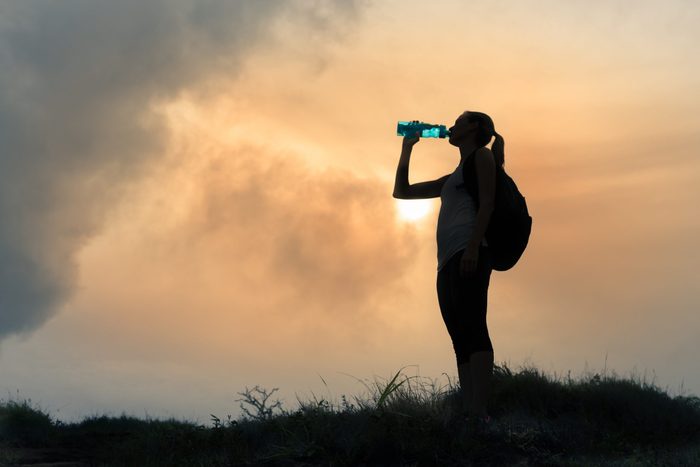 Female,hiker,drinking,bottle,of,water.