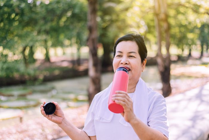 Senior,asian,woman,drinking,water,after,break,exercising,at,nature,healthy