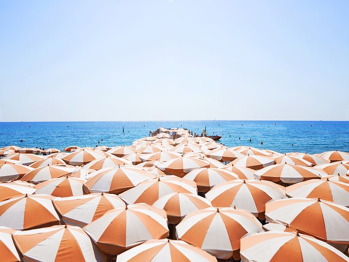 sun care tips | A,lot,of,orange,white,sun,umbrellas,on,a,beach,