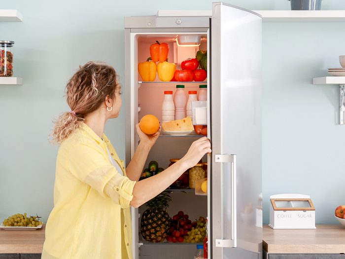 Woman,choosing,food,in,modern,fridge,at,home