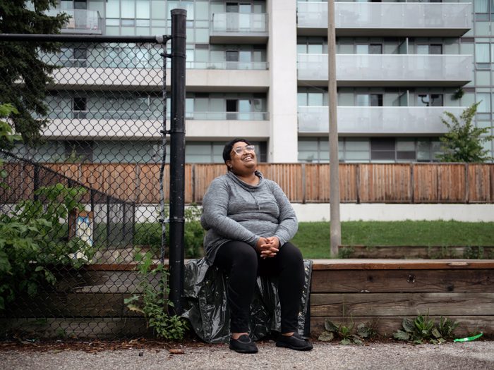 workplace-accommodations | writer krystal jagoo sitting in front of an apartment building