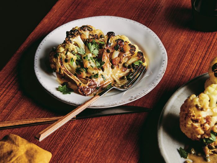 roasted cauliflower | image of roasted cauliflower with lemon and capers on a plate on a wooden table