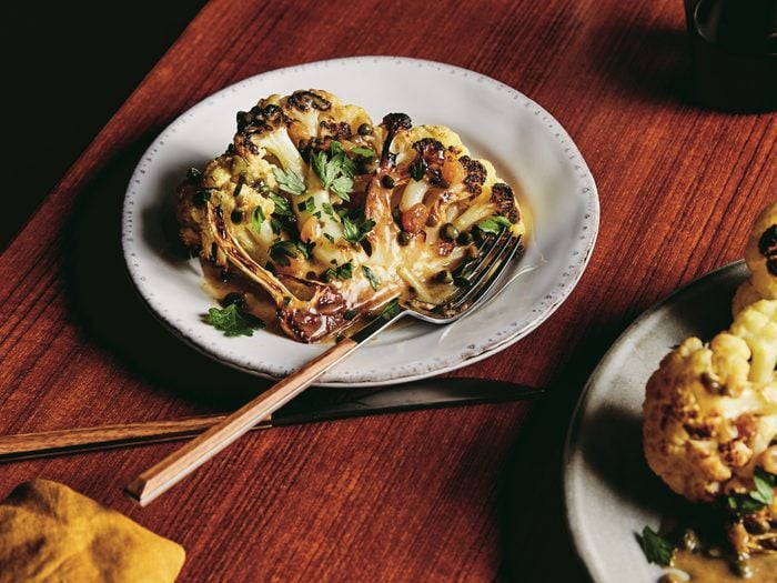 roasted cauliflower | image of roasted cauliflower with lemon and capers on a plate on a wooden table