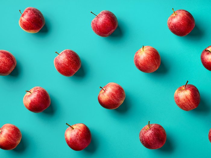 Colorful,fruit,pattern,of,fresh,red,apples,on,blue,background.
