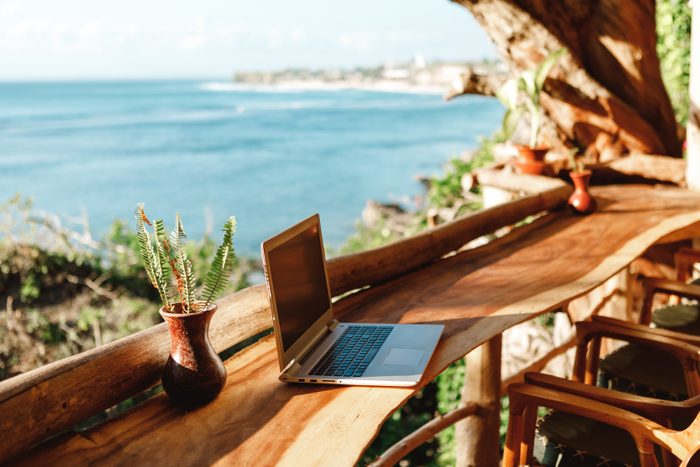 how to prevent employee burnout | laptop on a wooden table in a vacation destination