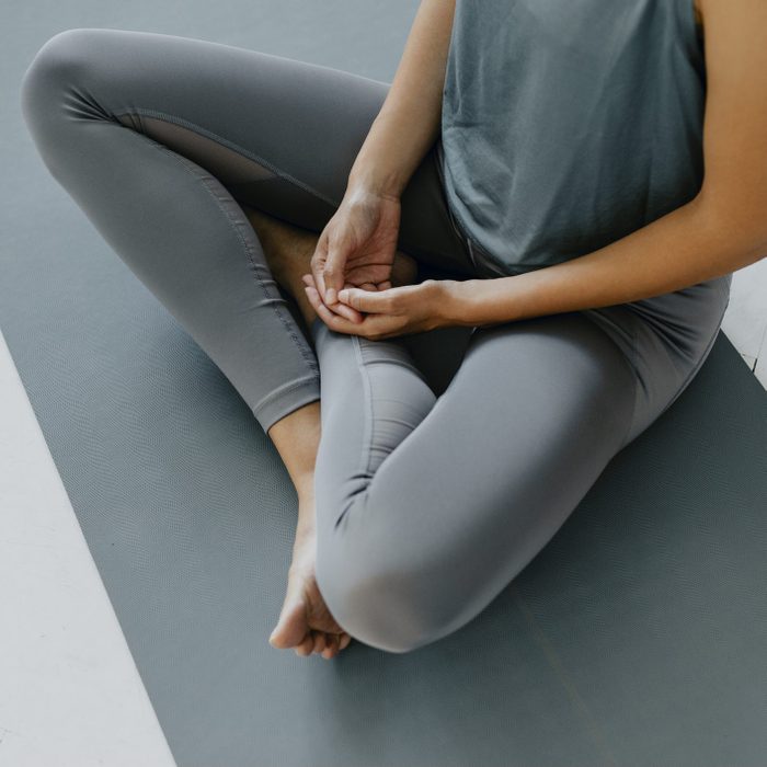 how to wash athleisure | Anonymous Woman Doing Yoga Practice On Her Bedroom Floor