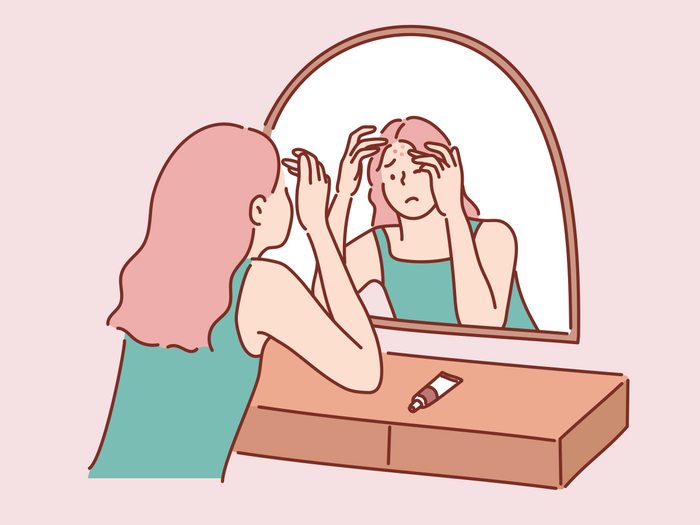 An illustration of a woman looking in a mirror and worrying about spots on her forehead