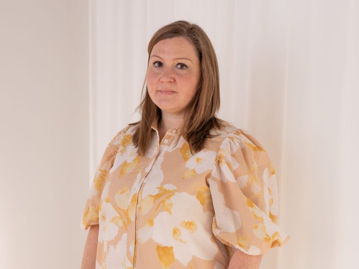 Photograph of Amanda Propp wearing a flowered yellow and white dress and looking serious.Digestive Disorder Symptoms Women Diagnosis Canada Amanda Propp By Kayla Rocca