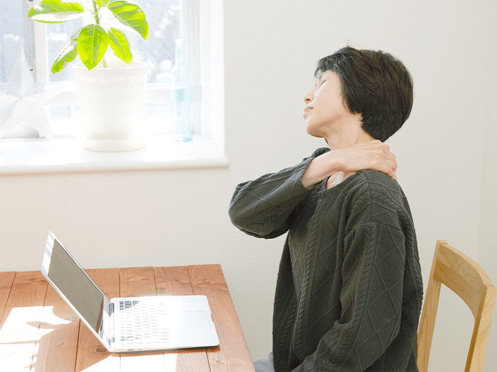 Frozen Shoulder Pain Exercises pain Hero | image of a woman clutching her frozen shoulder
