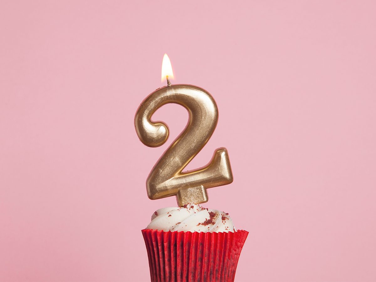 An image of a cupcake with a 2 candle on it representing 2022 Covid Pandemic Anniversary Feature