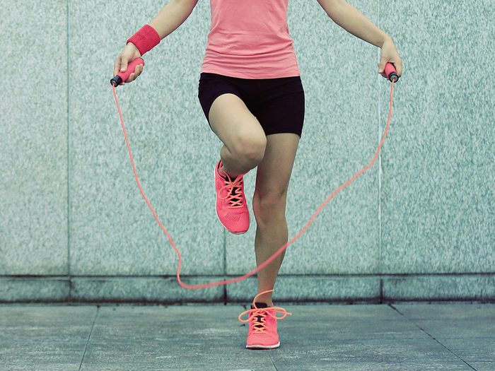 skipping rope | Young,fitness,woman,rope,skipping,against,city,wall