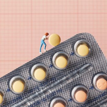 birth control pill | miniture of a woman pushing a birth control pill up a hill of pills
