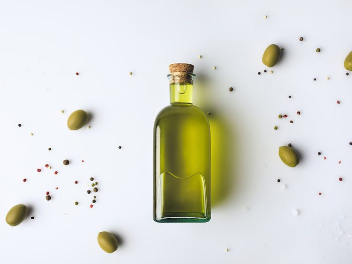 Top,view,of,glass,bottle,with,olive,oil,and,olives